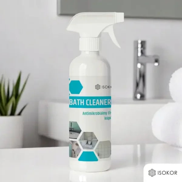 Flaske med badrengjøring spray på baderomsbenk ved siden av vask og hvite håndklær.